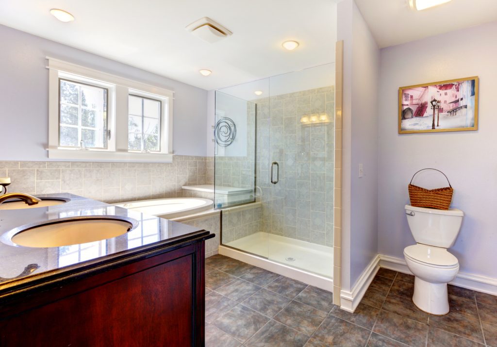 Light lavendar bathroom with large shower and sink.
